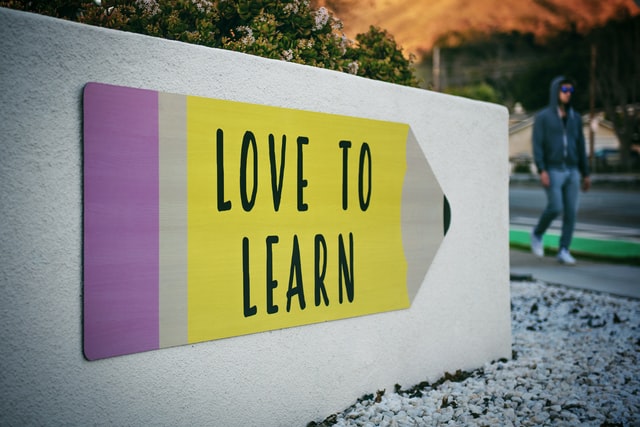  Sign in the shape of a pencil with the words "Love to learn." 