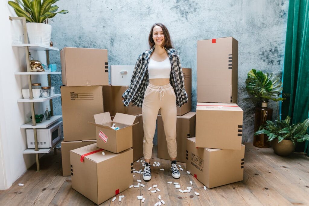 A girl standing between cardboard boxes