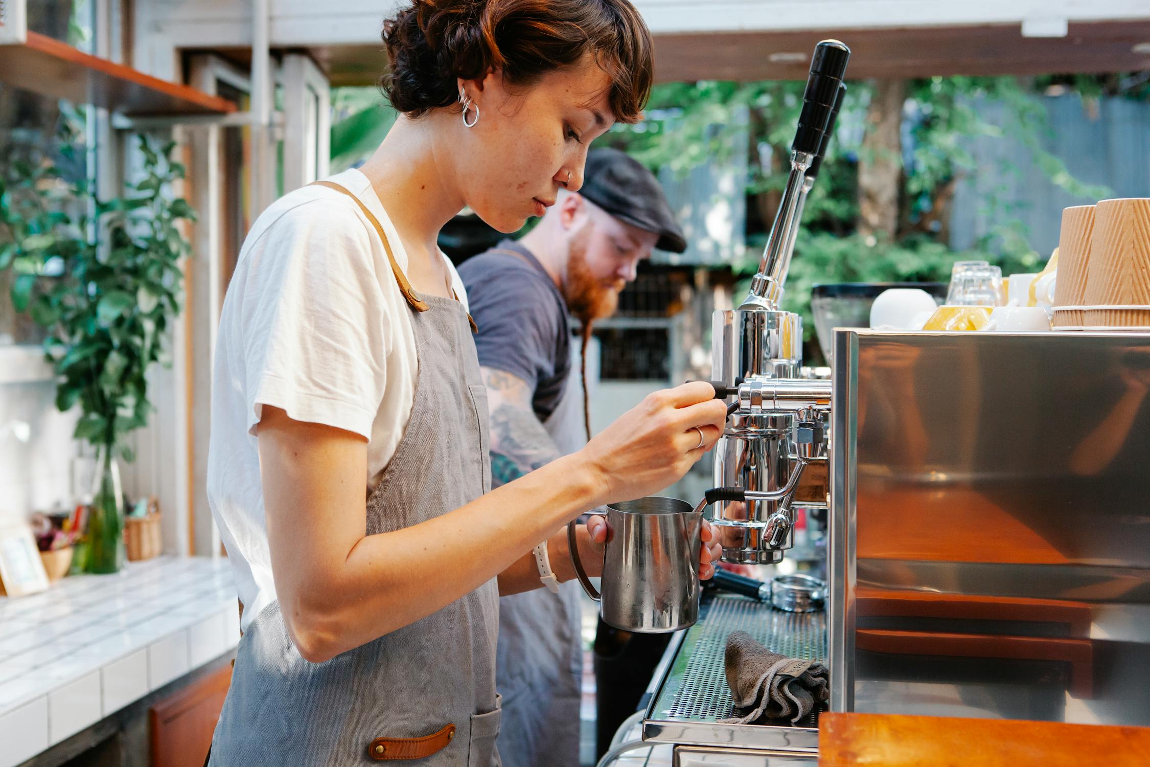 A young girl making coffee at a cafe 
