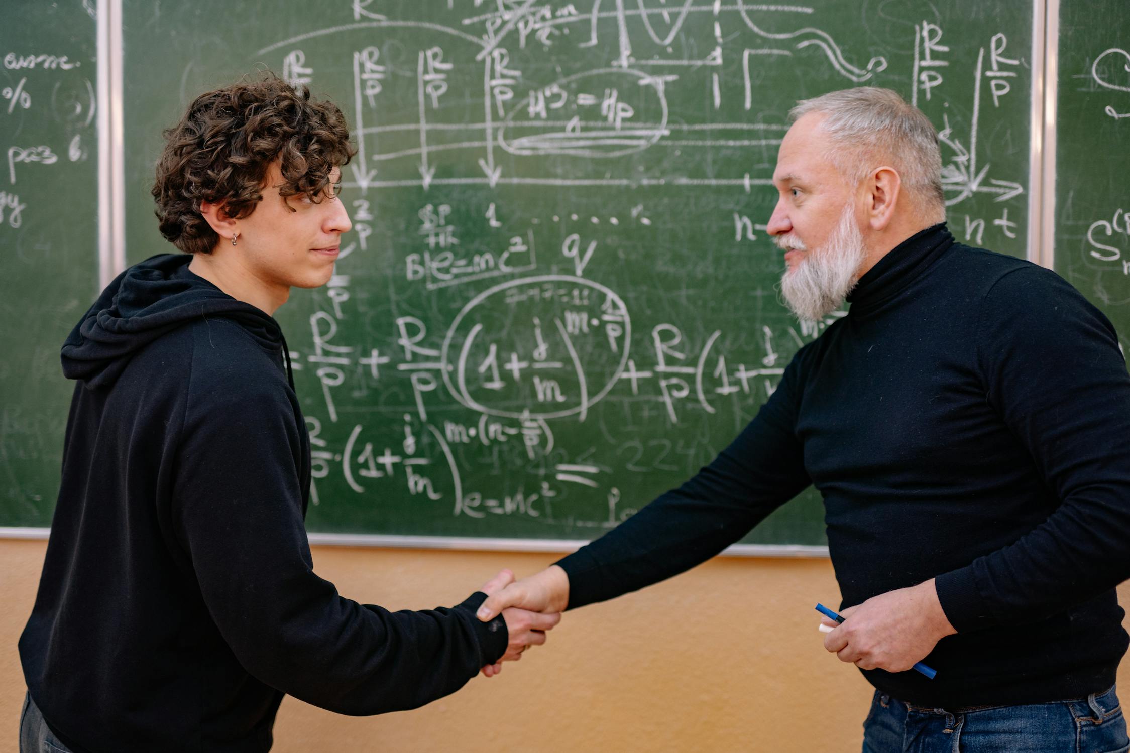 A student and a professor shaking hands