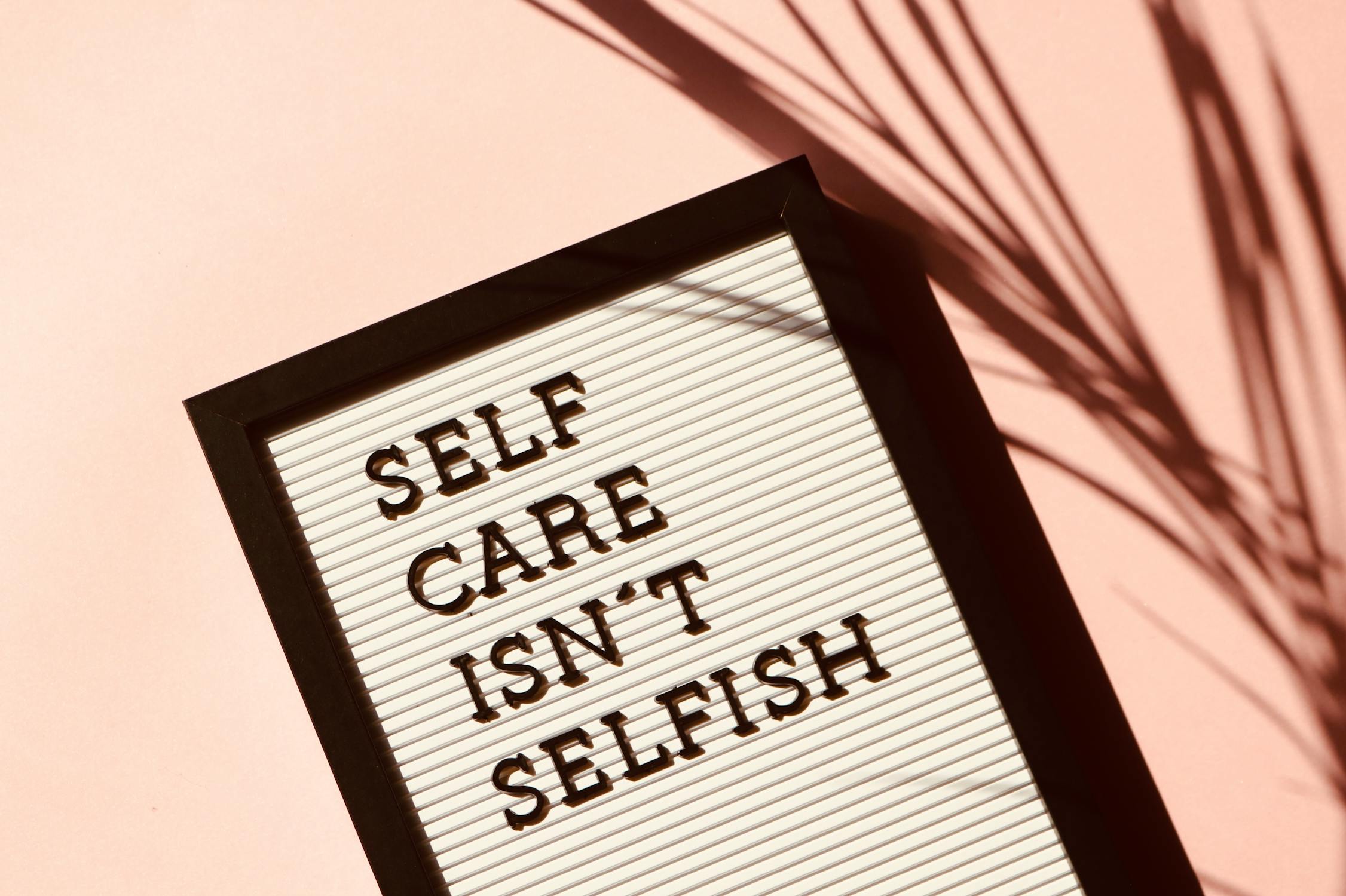 A photo in a black frame that says Self Care Isn’t Selfish.